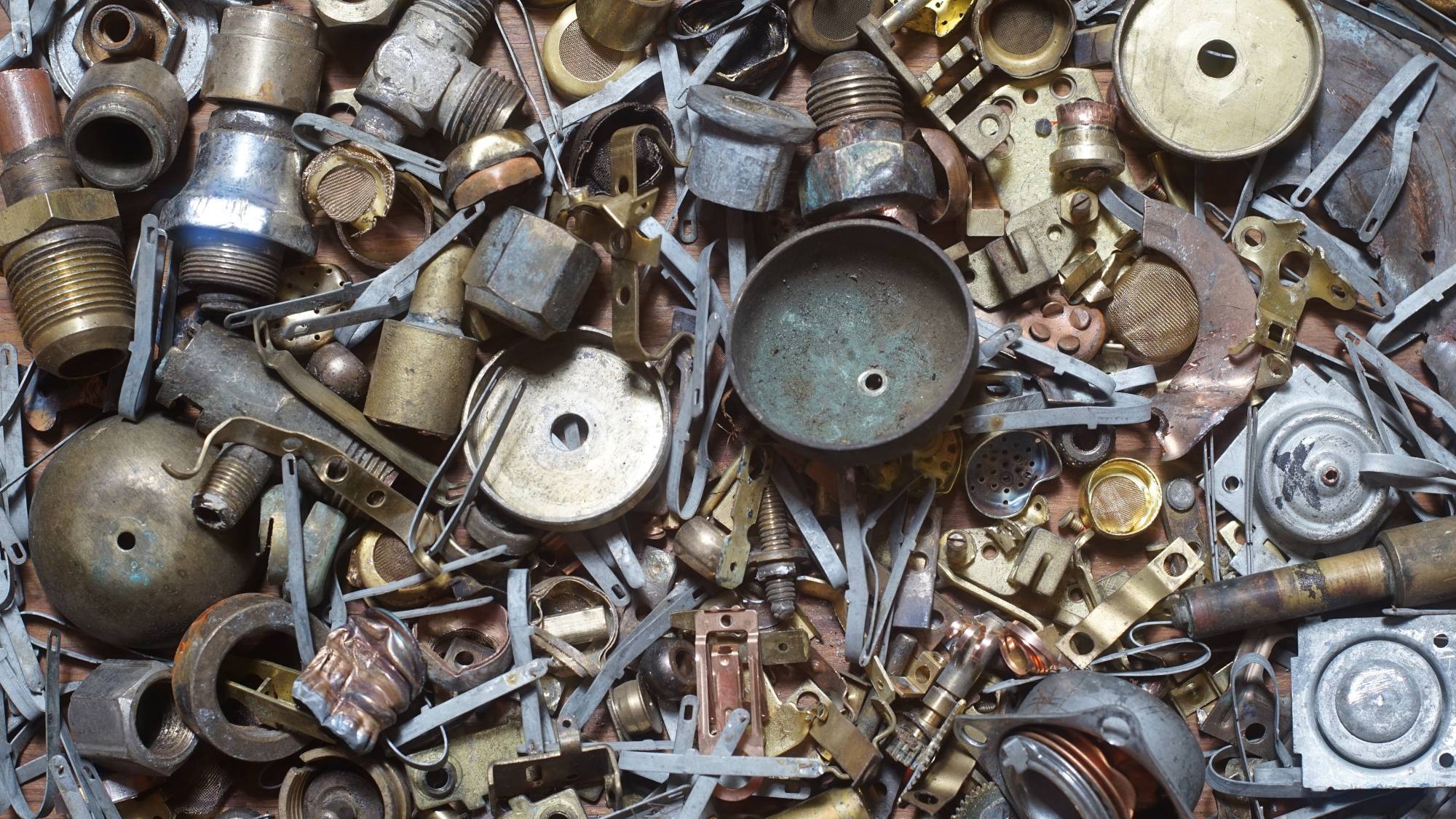 Dynamic Metal Recycling | A close-up view of a pile of assorted metal parts and components, including screws, bolts, washers, gears, and brackets. ferrous vs non-ferrous
